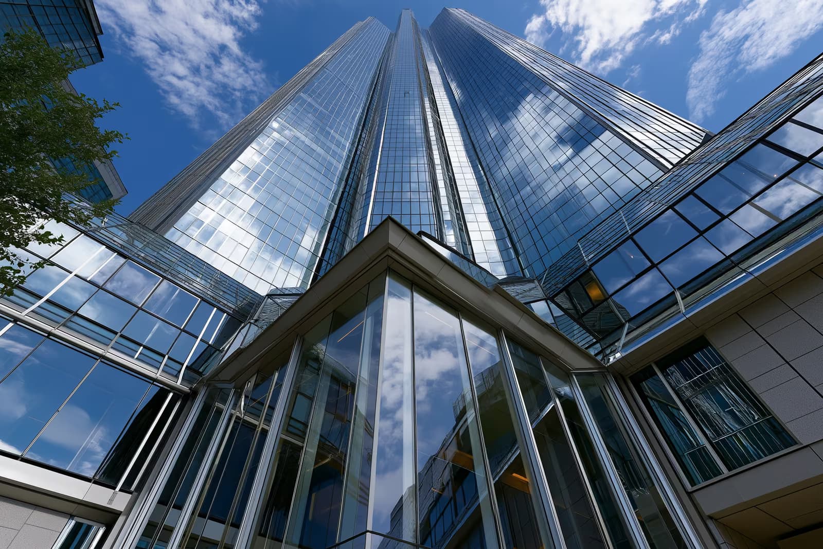 Une tour bancaire moderne en verre, située dans un quartier financier allemand, sous un ciel dégagé.