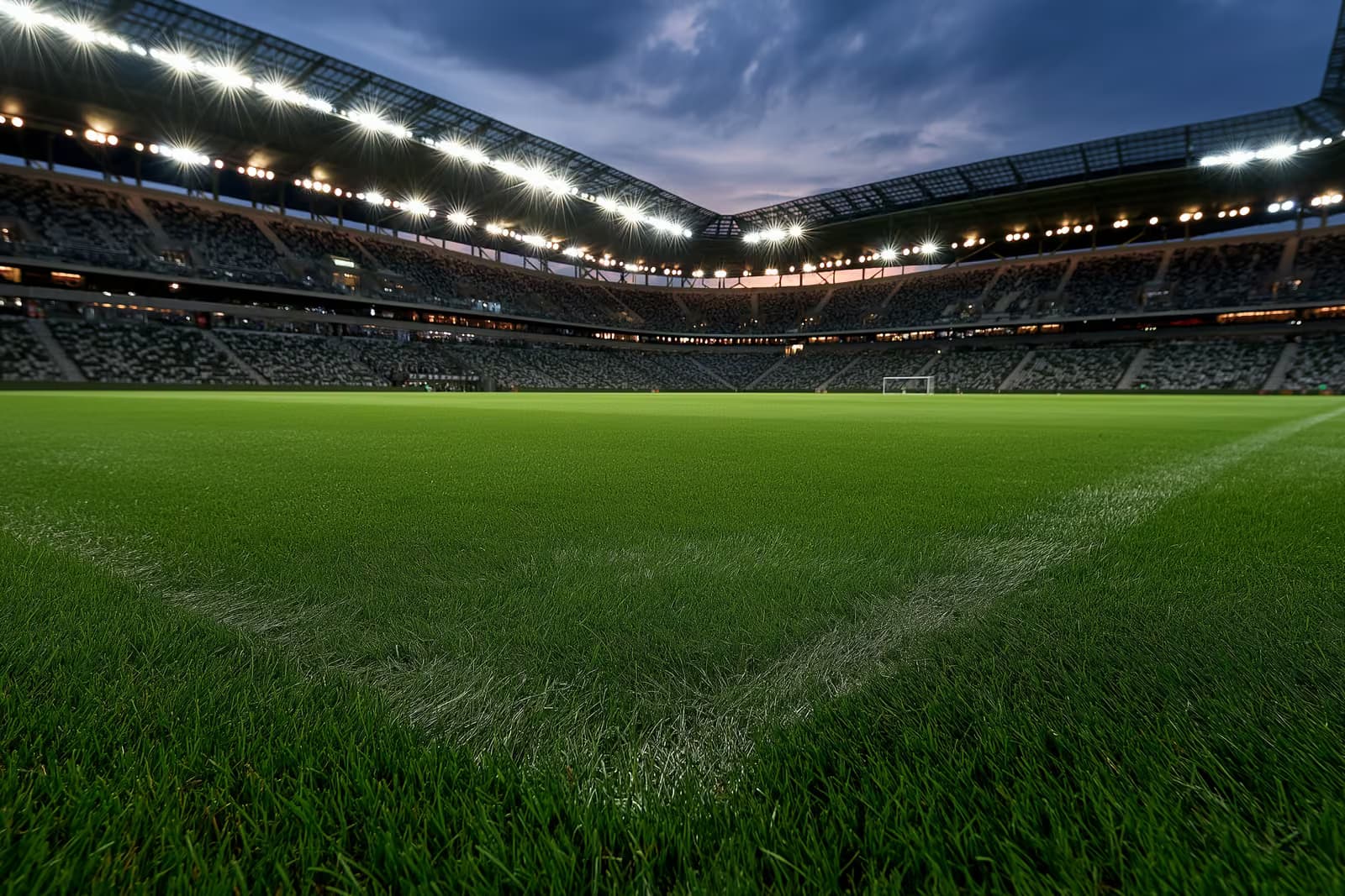 Un stade de football illuminé au crépuscule avant un match en soirée.