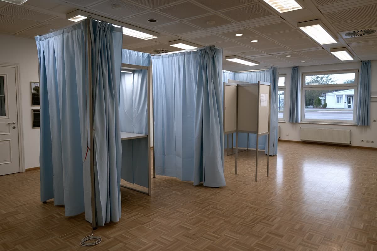 Un isoloir vide avec un crayon au bout d'une ficelle dans une salle communale allemande